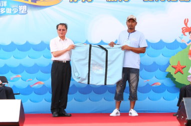 圖 4 　漁業署署長（左）致贈環保袋給漁民 